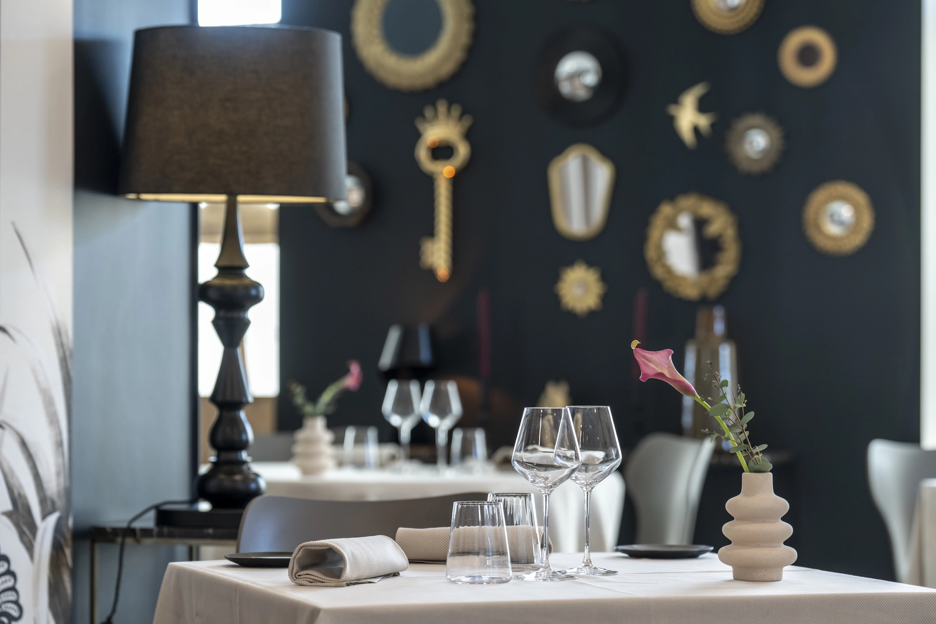Table dressée devant le mur aux miroirs dorés ornementaux, décor singulier de l'Auberge d'Arthaz