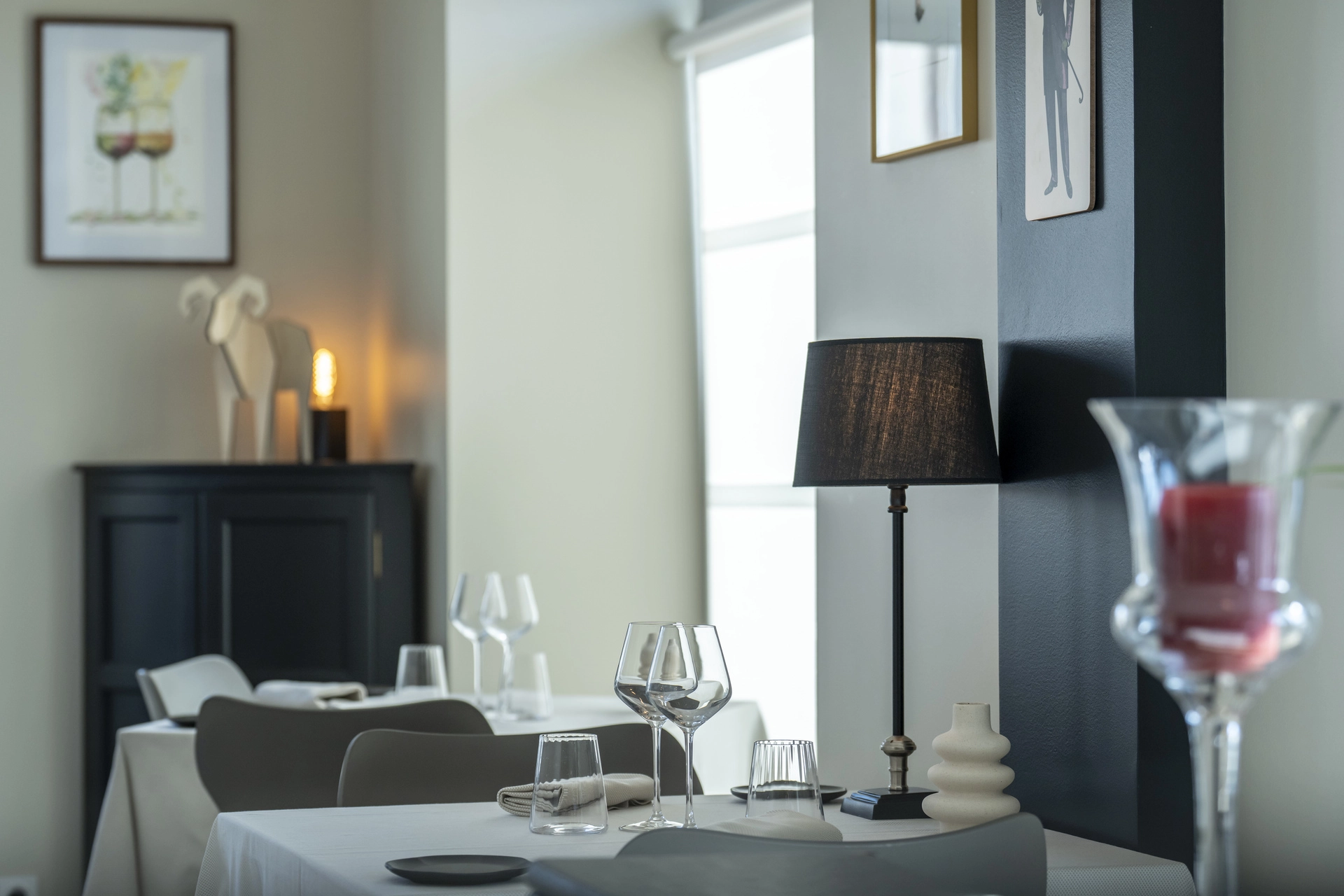 Coin intime de l'Auberge d'Arthaz avec buffet noir vintage, bougie votive et lumière feutrée