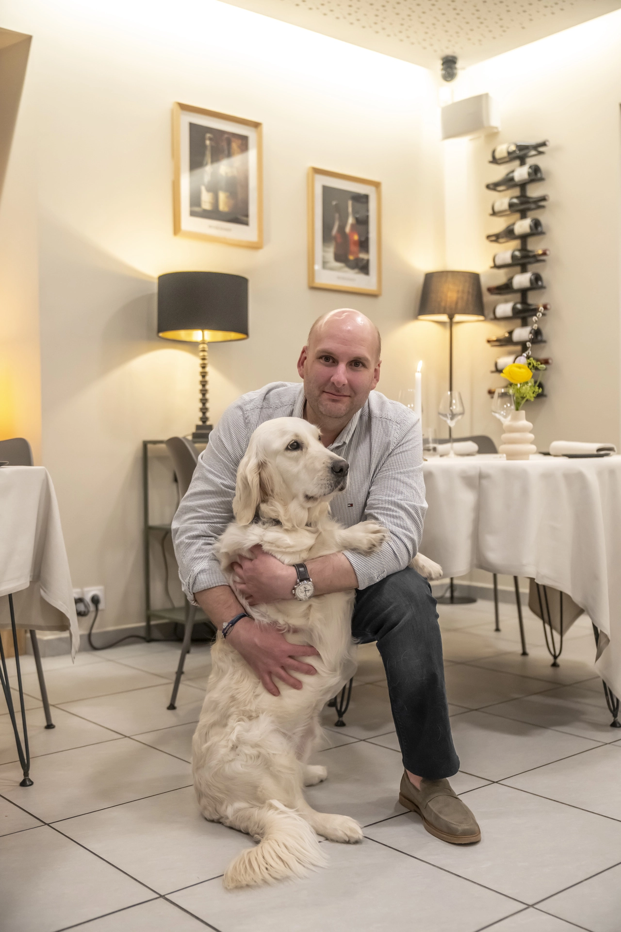 Jérôme, patron de l'Auberge d'Arthaz, avec son golden retriever dans la salle du restaurant