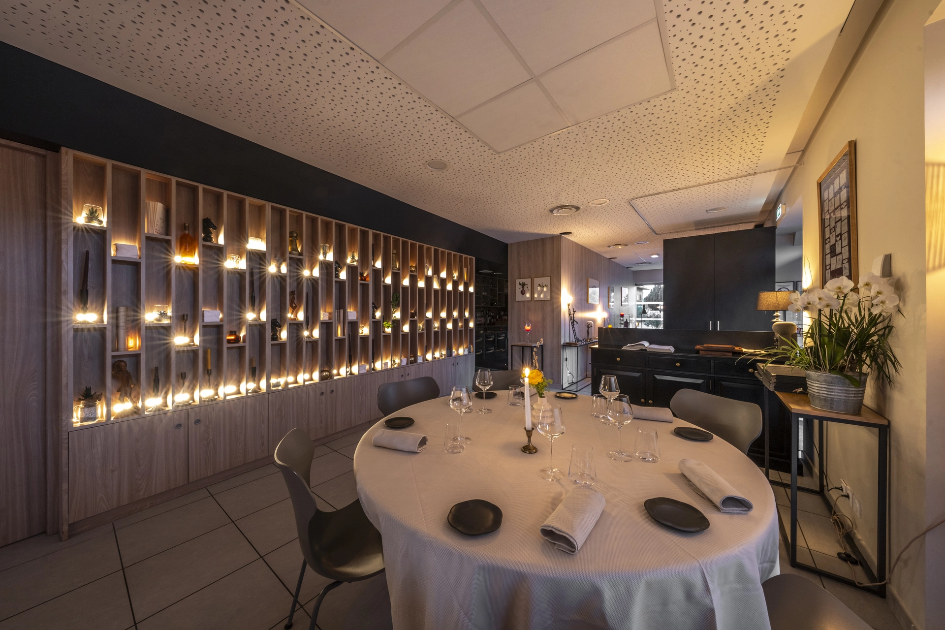 Cave à vins toute hauteur illuminée de l'Auberge d'Arthaz, table ronde dressée pour le service du soir